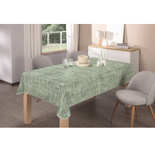 Matbord med en mönstrad duk, porslin och dekoration i en ljus matsal.