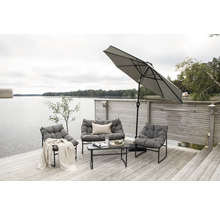 Terrass vid sjön med loungemöbler, parasoll och soffbord