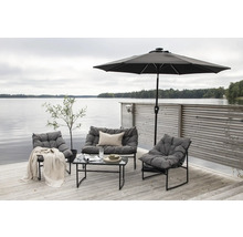 Trädgårdsmöbler med bord, stolar, bänk och parasoll på en träterrass vid sjön