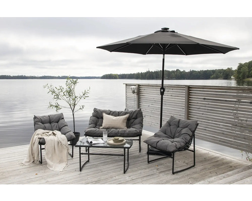 Trädgårdsmöbler med bord, stolar, bänk och parasoll på en träterrass vid sjön