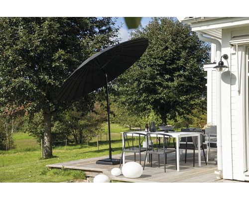Scen med en trädgårdsbordssats och ett parasoll på en träterrass