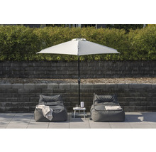 Miljöbild med två sittsäckar, ett vitt parasoll och ett sidobord i trädgården