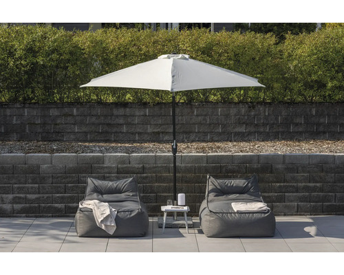 Miljöbild med två sittsäckar, ett vitt parasoll och ett sidobord i trädgården