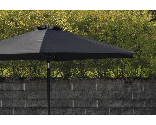 Svart trädgårdsparasoll framför en mur