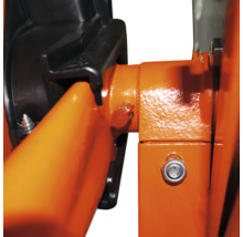 Närbild av en byggnadsställning med orange metallstag och svarta plastkopplingar.