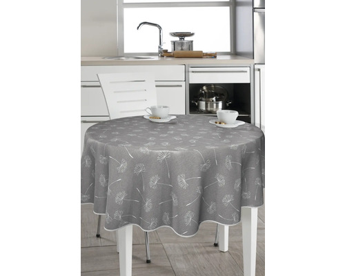 Runt bord med grå duk och maskrosmönster i ett kök.
