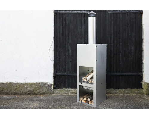 Modern trädgårdskamin i rostfritt stål med vedförvaring.