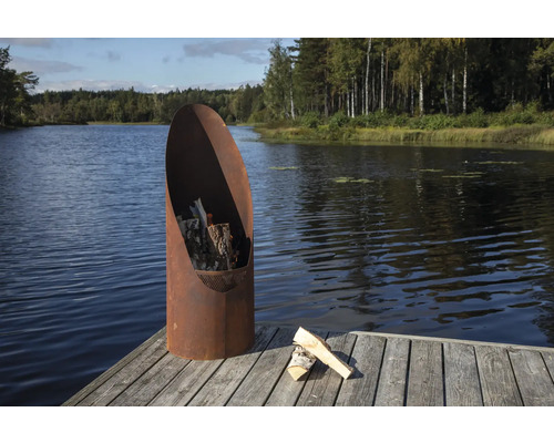 Eldstad av metall med ved på en träbrygga vid sjön