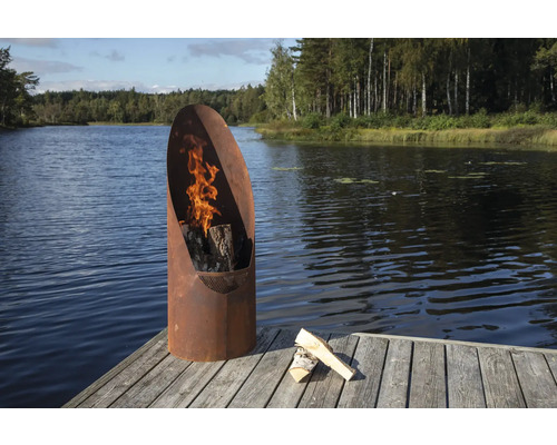 Eldstad i metall med trä på en träterrass vid sjön