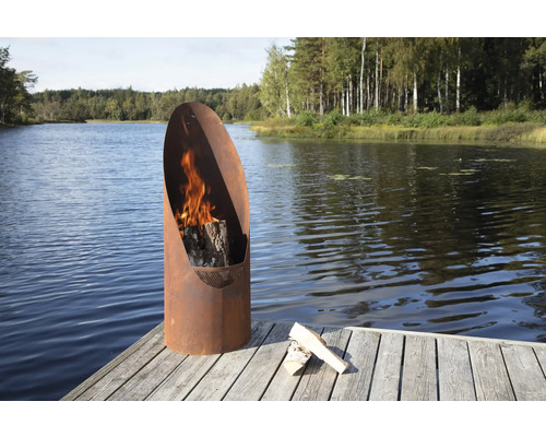 Eldstad av metall med ved på en brygga vid sjön