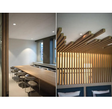 Bild av ett konferensrum med ett långt träbord och stolar samt den dekorativa träpanelen i ett sovrumstak.