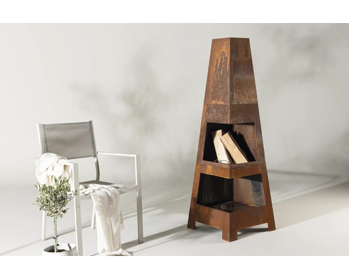 Trädgårdsscen med eldstad i metall, ved och stol