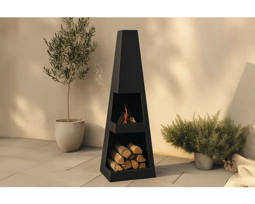 Svart eldstad i stål med vedförvaring för utomhusbruk.