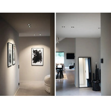 Hall med infällda spotlights, inramade bilder och spegel