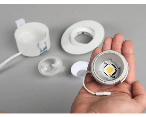 Infälld spotlight med LED-lampa i handen