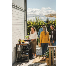 Scen av en grillfest med grillvagn och flera personer utomhus.