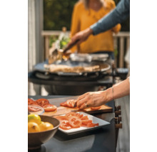 Två personer lagar mat med en kniv och en grill.