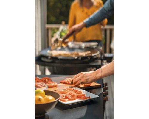 Två personer lagar mat med en kniv och en grill.