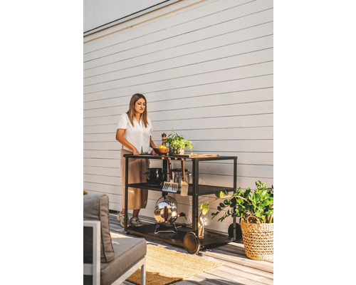 Grillvagn med kvinna, grillverktyg och dekoration utomhus