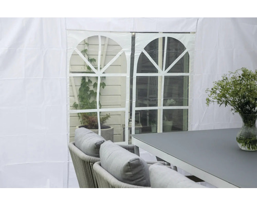 Scen med trädgårdstält, bord, stolar och blomvas