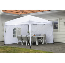 Vitt partytält med bord och stolar i trädgården