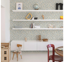 Dekorerat rum med blommigt tapet, vita hyllor och möbler.