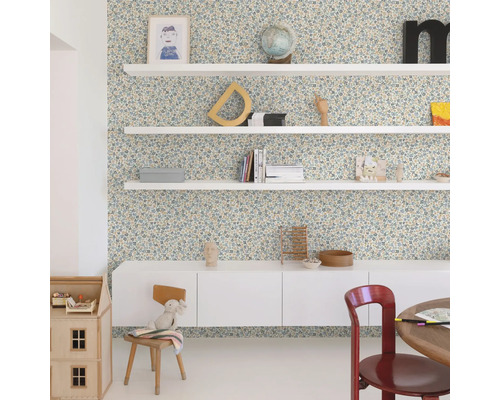 Dekorerat rum med blommigt tapet, vita hyllor och möbler.