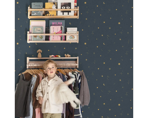 Barnrum med trähyllor på en stjärnprydd vägg och en pojke framför en klädställning