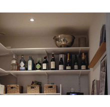 Hylla med spritdrycker, vinflaskor och förvaringskorgar