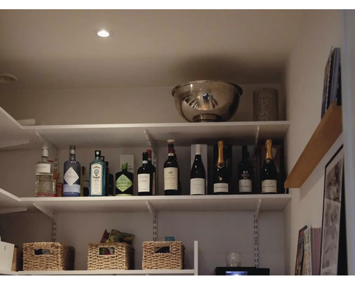 Hylla med spritdrycker, vinflaskor och förvaringskorgar