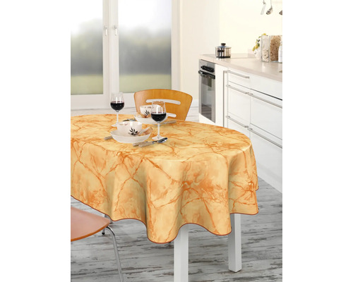 Matbord med vaxduk och porslin i ett ljust kök.