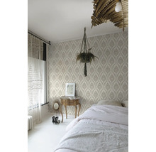 Sovrum med mönstrad tapet, säng, sängbord och krukväxt