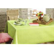 Dukat matbord med grön duk, porslin, karaff, blommor och bok