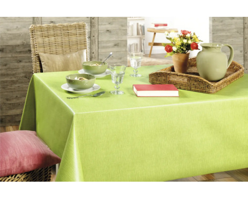 Dukat matbord med grön duk, porslin, karaff, blommor och bok