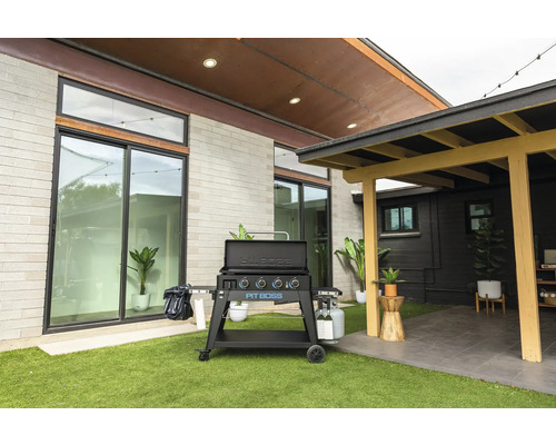 Grillplatta i utomhusmiljö med gräsmatta och terrass