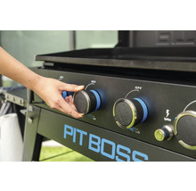 Pit Boss Grill med en hand på temperaturregulatorn