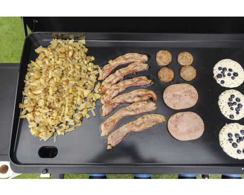 Frukost tillagad på en grill med stekt potatis, bacon, korv, köttfärslimpa och blåbärspannkakor