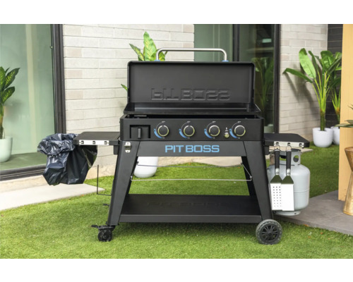 Pit Boss grill med öppet lock, sidohyllor, soppåsehållare, propangasflaska och grillverktyg.