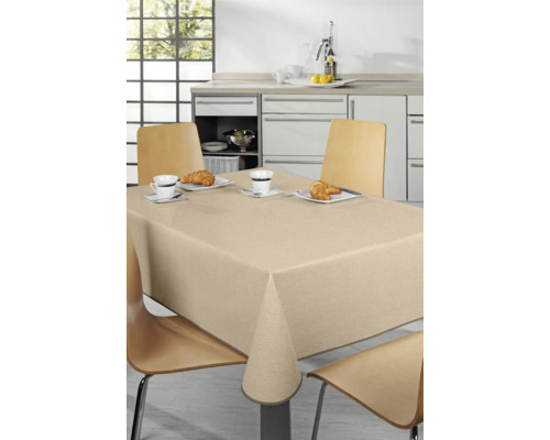 Dukat matbord med beige duk i ett ljust kök.