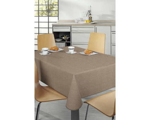 Dukat matbord med beige bordsduk i ett kök