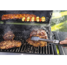 Grillscen med biffar, revben och grönsaksspett tillagade på en grill