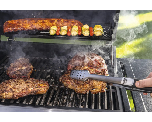 Grillscen med biffar, revben och grönsaksspett tillagade på en grill