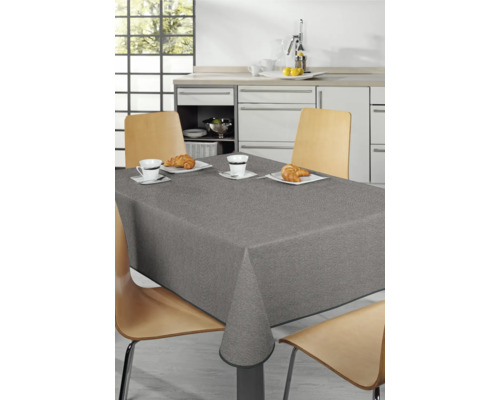 Matbord med grå bordsduk och porslin i ett ljust kök.