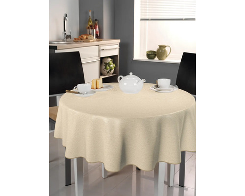Beige duk på ett runt bord i ett kök med porslin