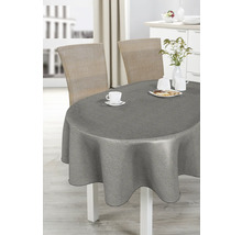 Matbord med grå duk, porslin och rottingstolar i ett ljust rum.