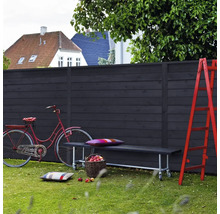 Scen med trästaket, bänk, cykel och stege i trädgården