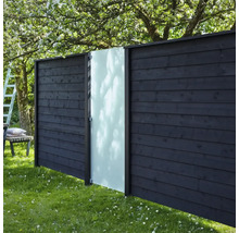 Trästaket med glaselement i en trädgård