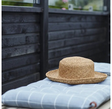 Stråhatt på rutig kudde framför trävägg