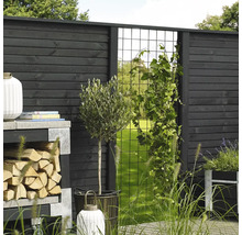 Trädgårdsbild med trästaket, klätterstöd och planteringar för ett naturligt utseende