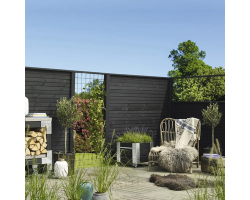 Anlagd trädgård med trästaket, blomlådor, stol och dekorationer